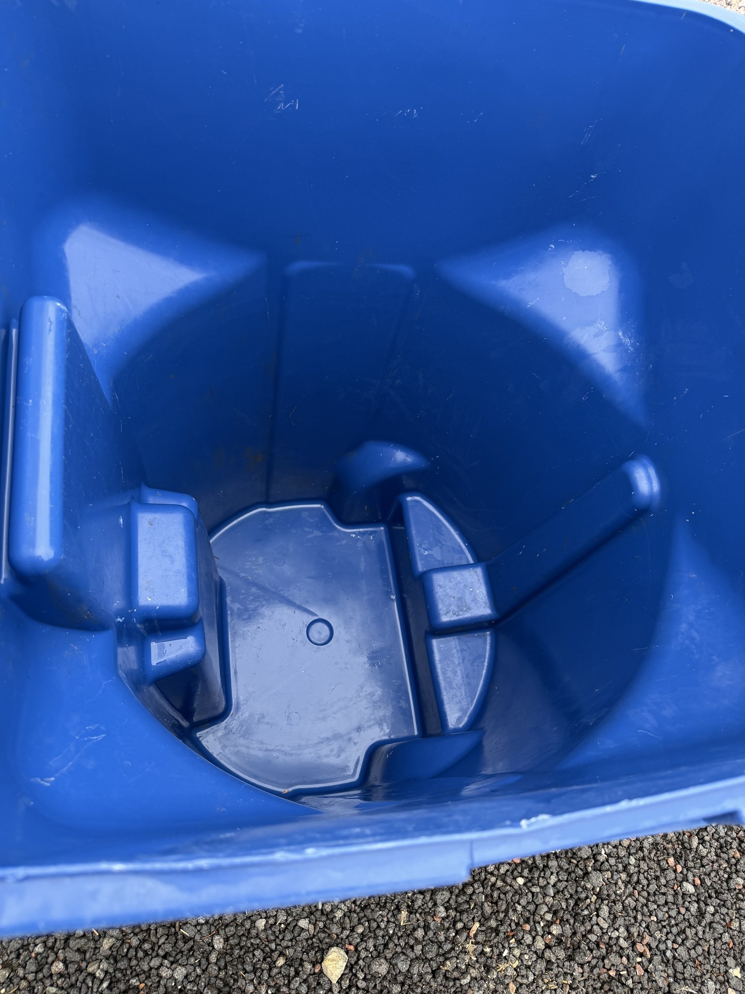 A clean blue residential trash can after service